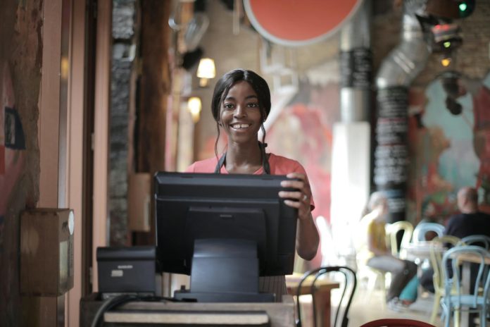 pexels-photo-3801426 cheerful black waitress standing at counter