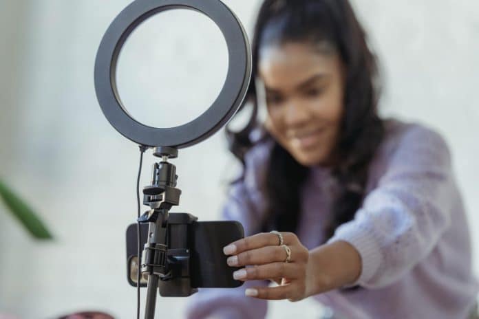 pexels-photo-6954220 happy young black woman setting up smartphone before shooting podcast