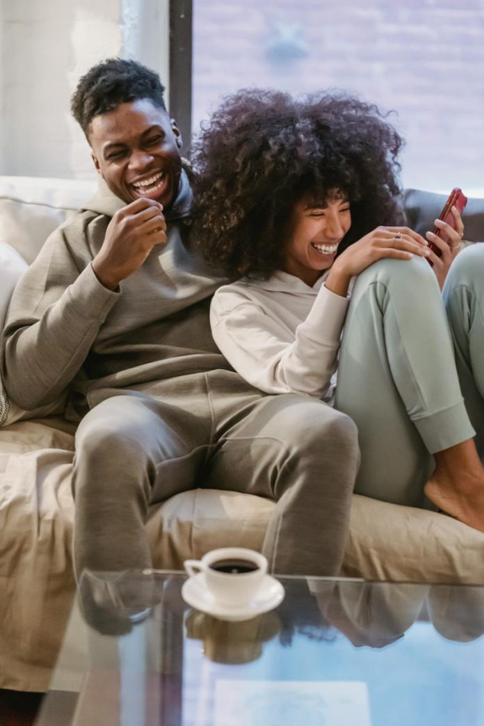 pexels-photo-6579102 happy black couple on couch with smartphone