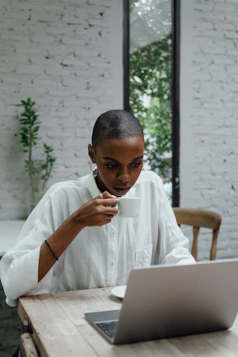 serious black businesswoman using laptop while sitting in cafe finance and budgeting